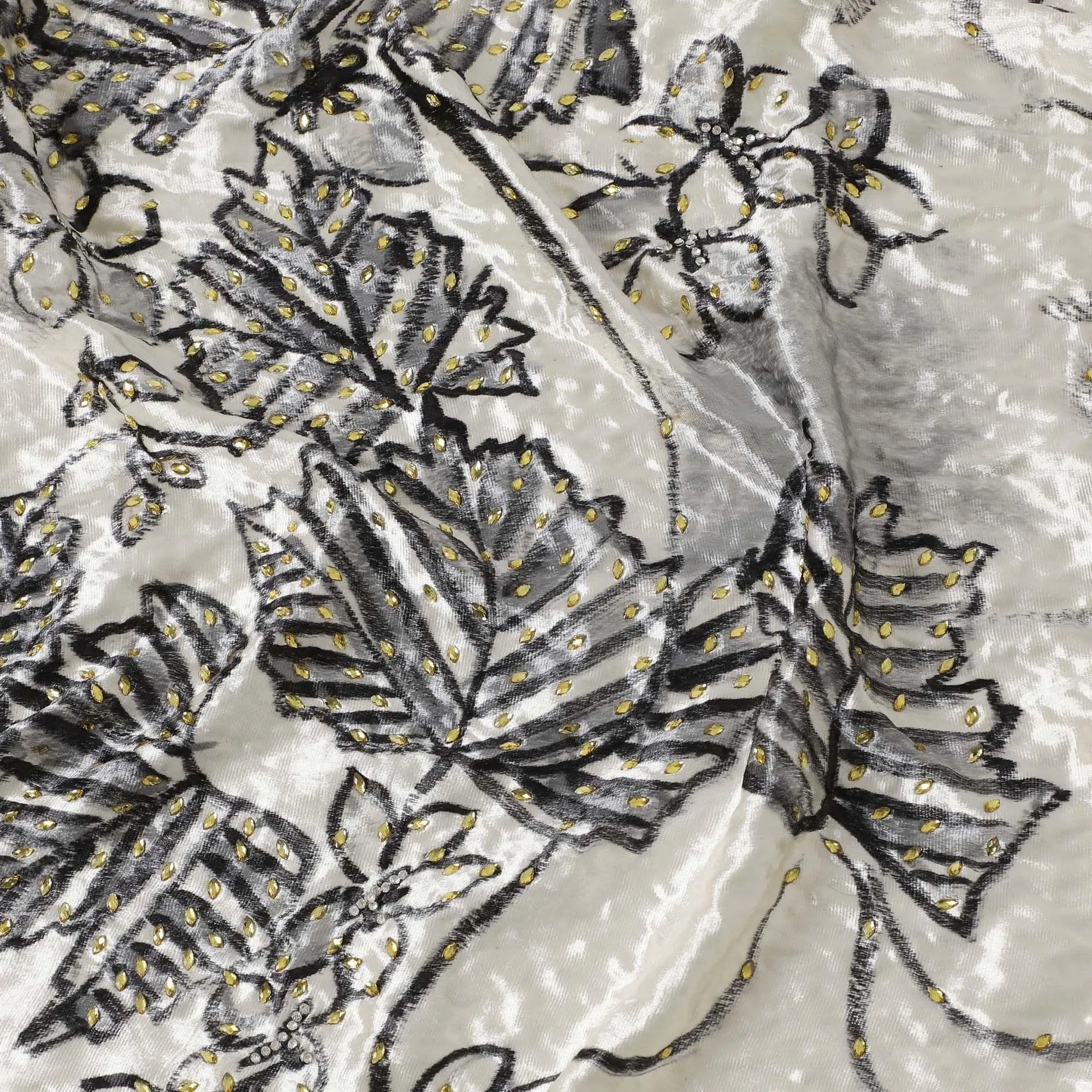 Macaroon Beige Rayon velvet fabric with charcoal grey print having green and silver stonework in leaf design